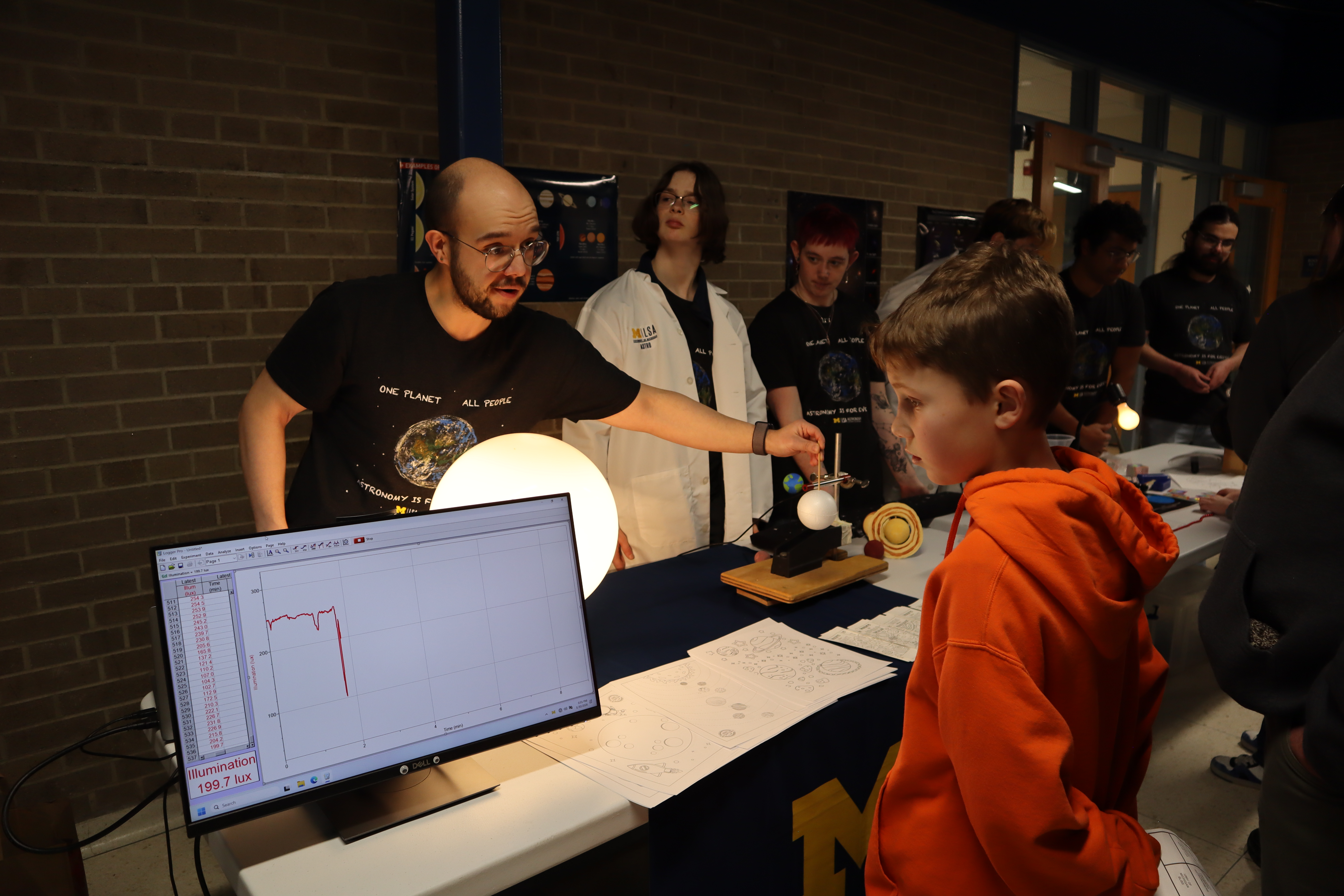 Levi explaining exoplanet transit light curves to elementary schooler